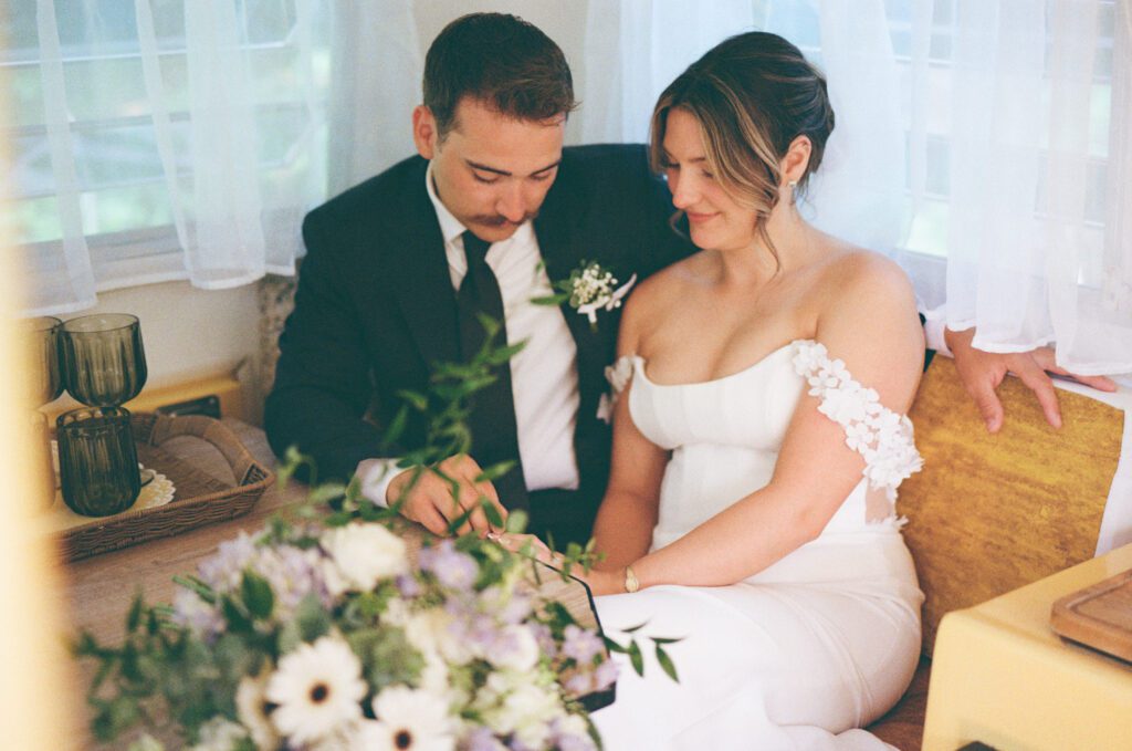 bride and groom admire their rings inside their 1973 Trillium camper
