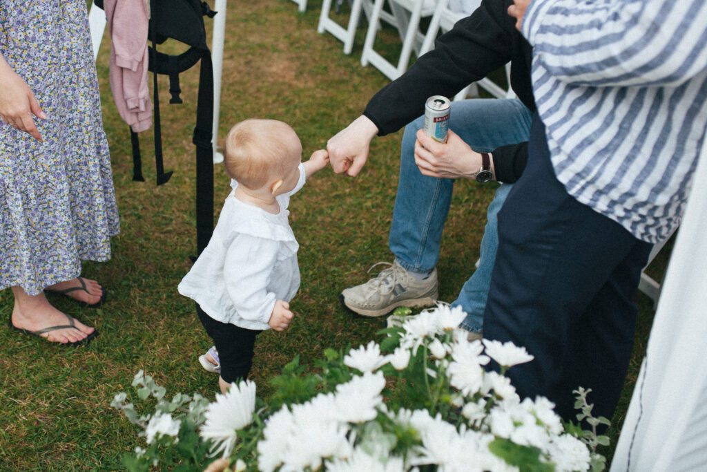 a toddler fist bumps wedding guests at campground wedding