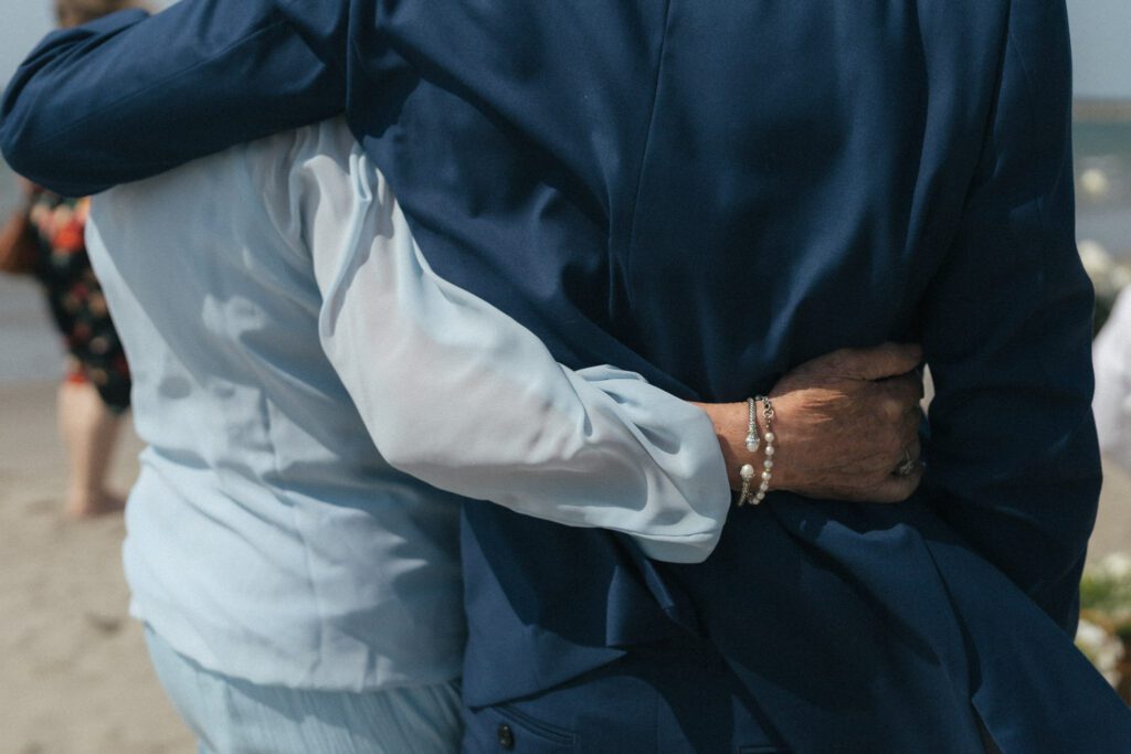 a woman in a blue dress wraps her arms around a man in a blue suit