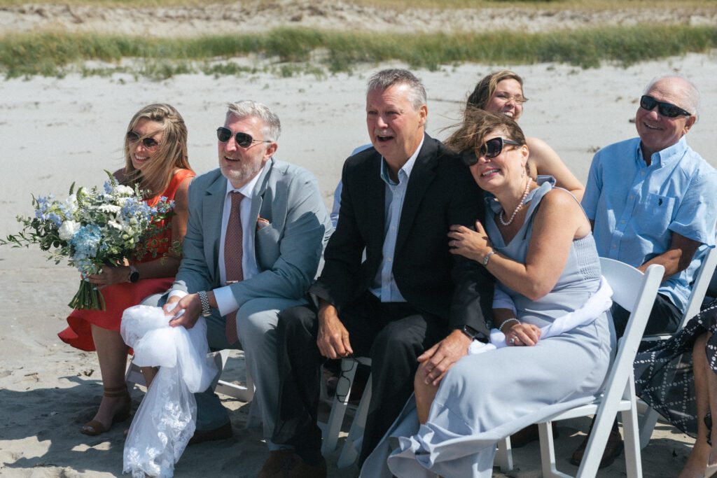 bride's parents laughing during intimate wedding ceremony on the beach in Newfoundland