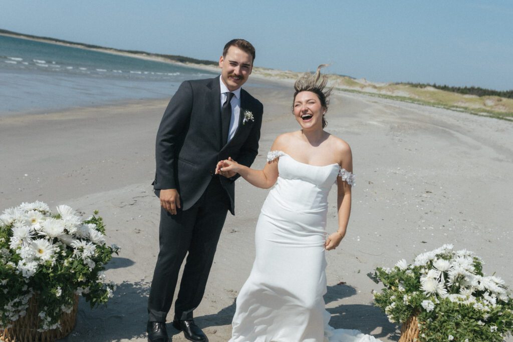 bride jumps in the air after first kiss on the beach in Gros Morne