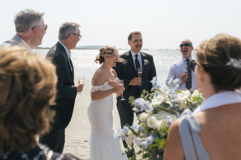 bride and groom laugh as they toast their guests