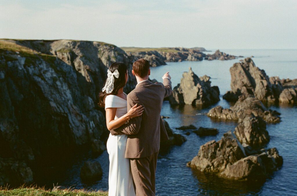 groom points out sea stacks to bride in Newfoundland, Canada