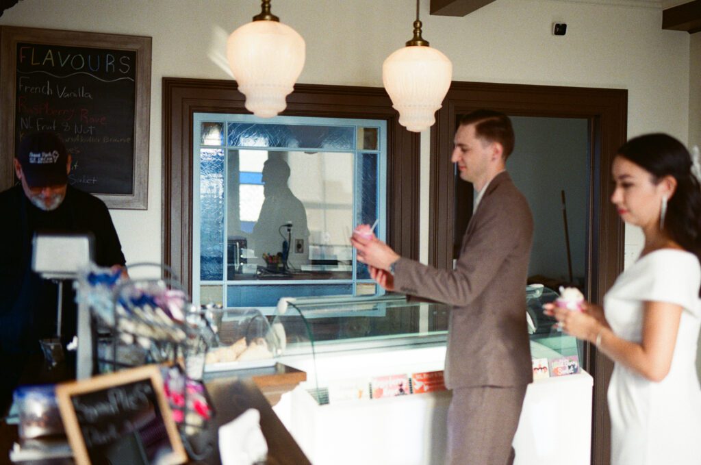 bride and groom buy ice cream in a gelato shop