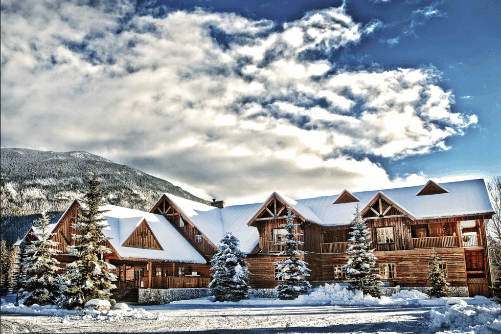 a large cedar chalet at Glacier House Resort in Revelstoke, BC covered in snow