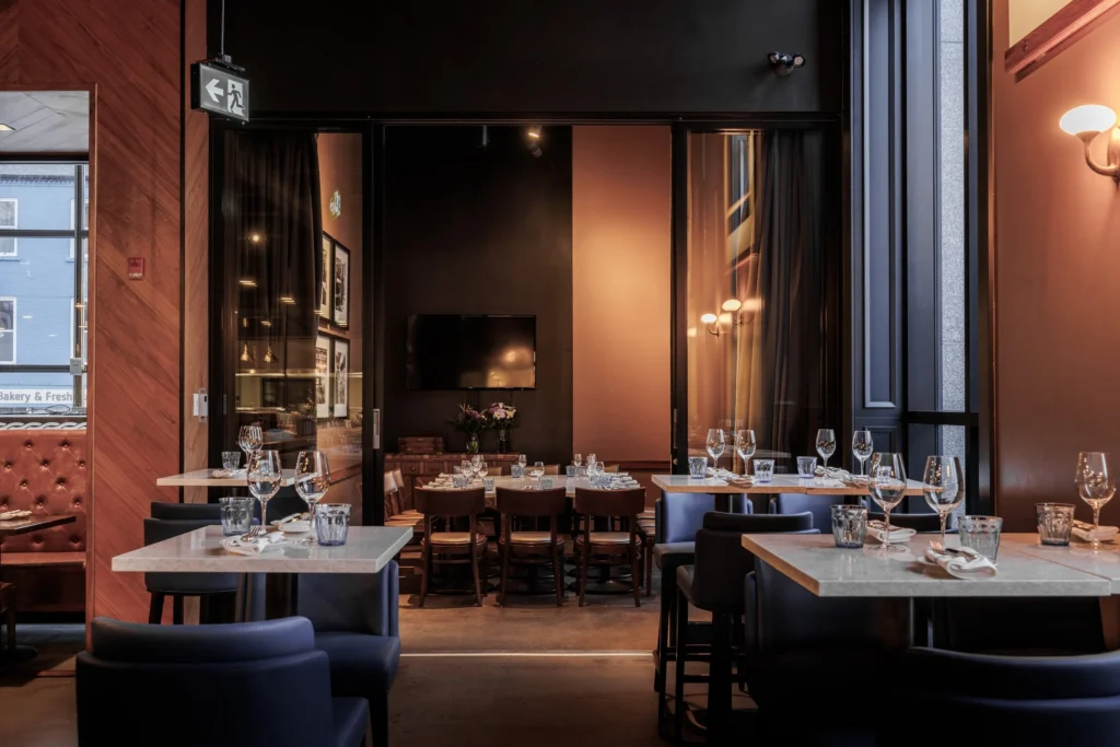 tables set for dinner in a sleek modern restaurant with elegant lighting