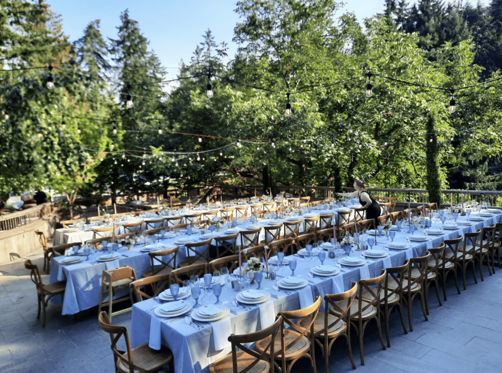 long dinner tables are set up for a wedding on a restaurant terrace on Vancouver Island