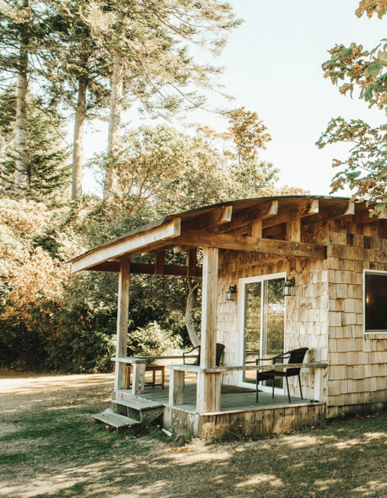 a cedar cottage sits on a beautiful sunny lot with trees at wedding venue on Hornby Island